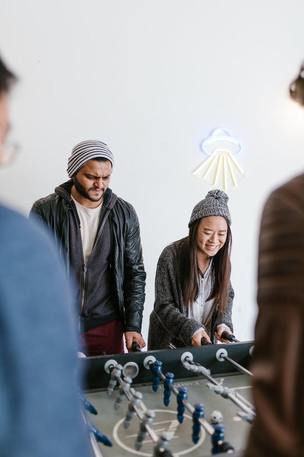  a_man_and_a_woman_playing_a_table_game_of_soccer