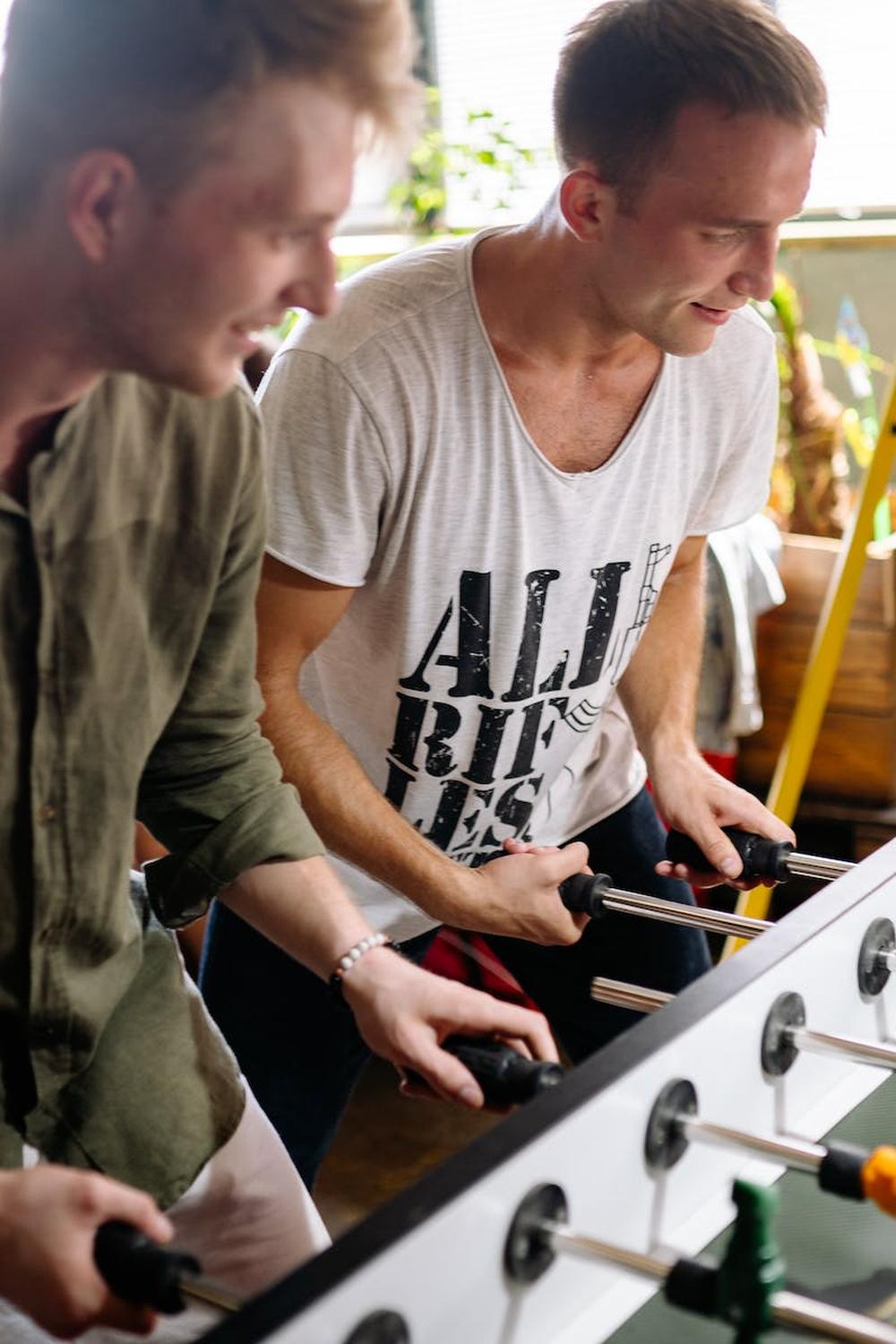  two_men_playing_foosball